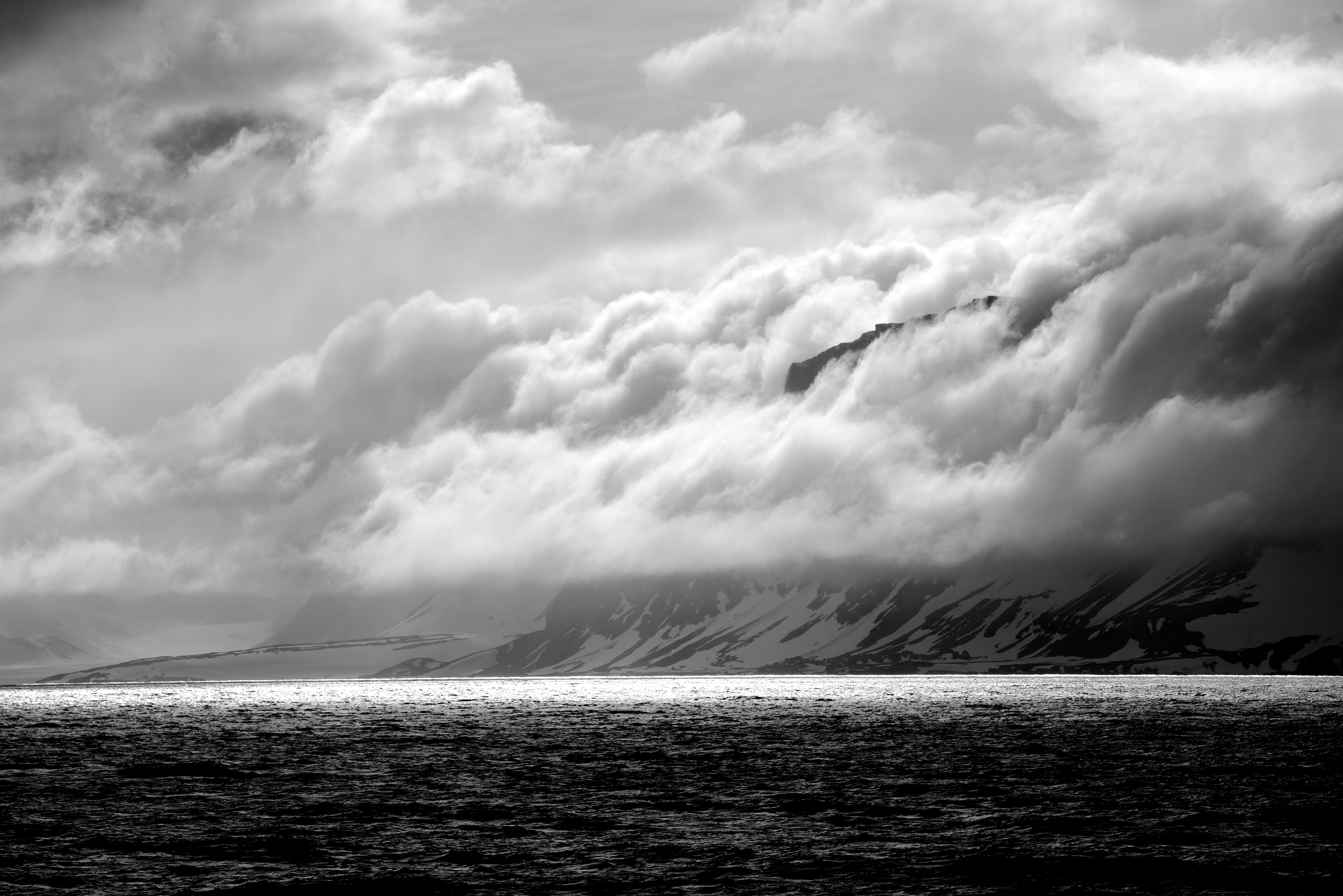 Black and white cliff beside backlit ocean - Nick Dale - Private Tutor